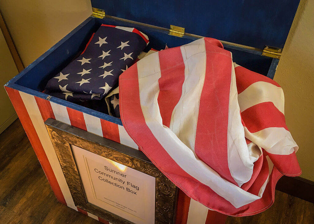 Flags in a box with a wood floor beneath.
