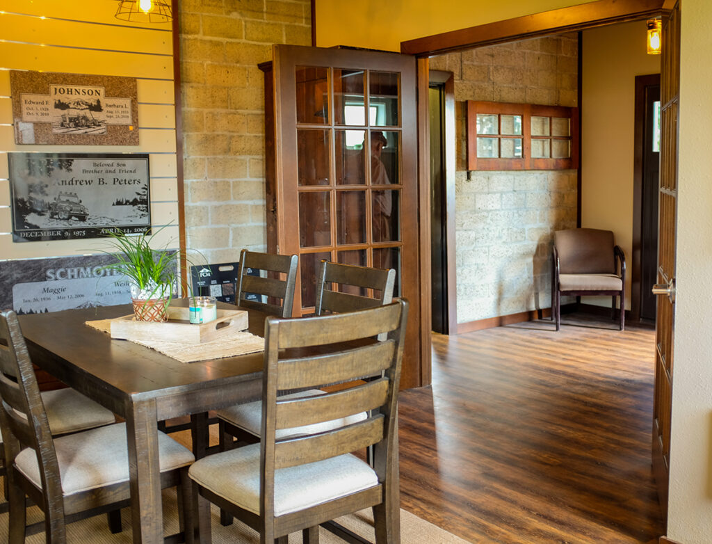 Office space with a table and chairs, sample markers on the wall and glass doors leading to the entry.